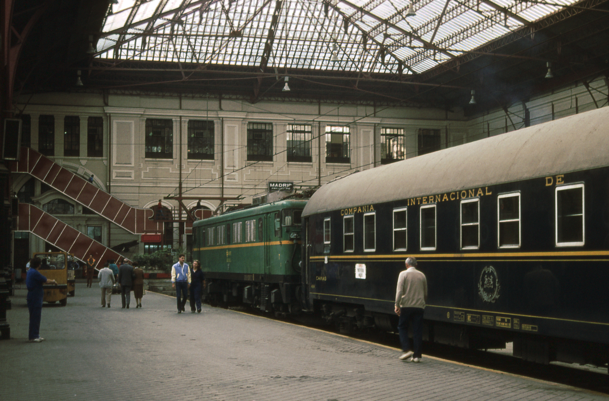 Die Reisenden des  Rias Bajas Expreso  haben mittlerweile ihren Weg in das Verkehrsgewühl der spanischen Hauptstadt gefunden, so lassen sich ein Schlafwagen der CIWL und die Lok 269 086 ungestört fotografieren. Der Exp. 854 war von 21.30 bis 8.52 auf der 679 km langen Strecke von Vigo am Atlantik nach Madrid unterwegs. Oktober 1983.
Canon AE1, Canoscan, GIMP.