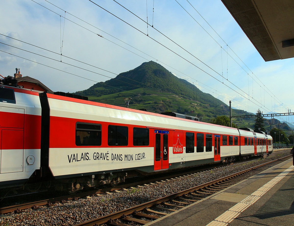 Die relativ neuen Zwischenwagen der NPZ-Züge (RBe 560); gebaut 2008-2009: Hier Wagen 29-43 405 der Züge durch das Wallis. Sie tragen den Werbespruch für die Region auf Deutsch und Französisch (Deutsch:  Wallis - ins Herz gemeisselt ). Diese Wagen fügen sich in die Pendelzüge der Organisation RegionAlps SA ein, eine Partnerschaft der Schweizerischen Bundesbahnen SBB-CFF und der Transports de Martigny et Régions TMR. Aufnahme in St.Léonard, 18.Juli 2019 