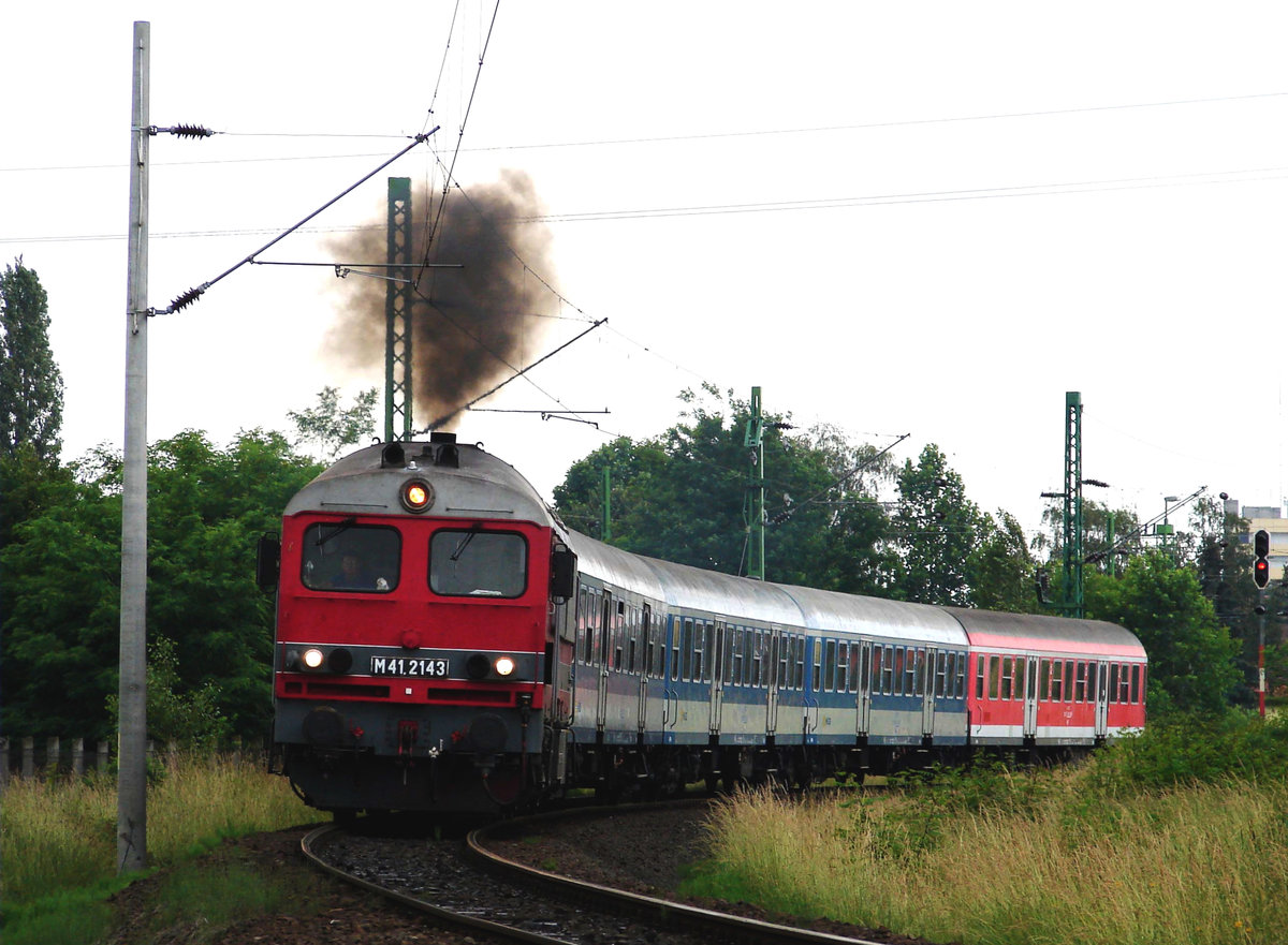 Die retrolackierte M41 2143 mit einem Eilzug von Celldömölk nach Győr kurz nach der Abfahrt von Bahnhof Celldömölk.
Herzlichen Dank an die Tfzf für den Rauch!
Celldömölk, 07.06.2008.