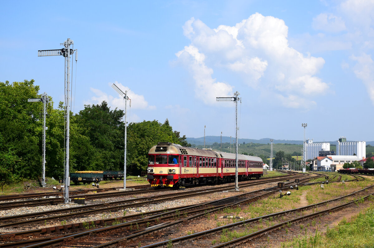 Die Retrolackierte Triebwagen 854 009 mit einem Regionalzug verlässt den Bahnhof Kyjov in Richtung Veselí nad Moravou.
26.08.2022.