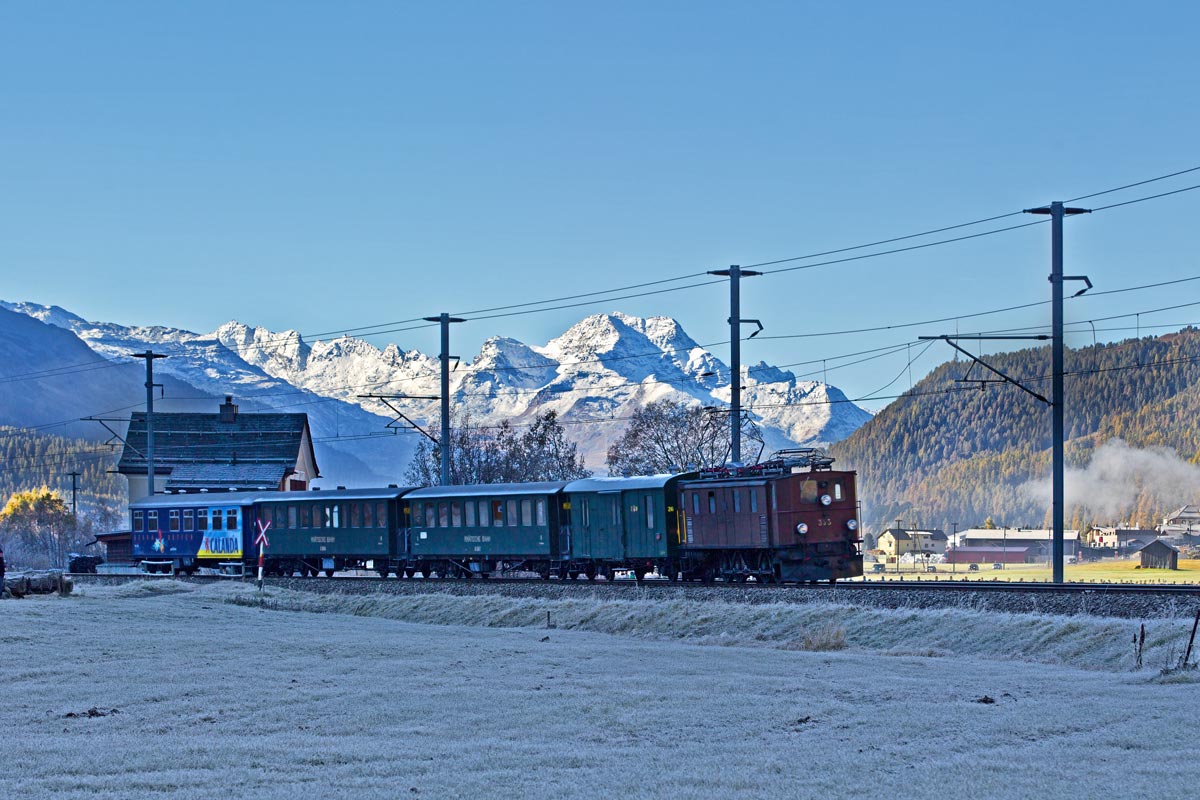 Die RhB Elektrolokomotive Ge 4/6 Nr.353 fährt am frühen Morgen mit dem Lunghin-Express bei Bever vorüber.Bild vom 16.10.2016