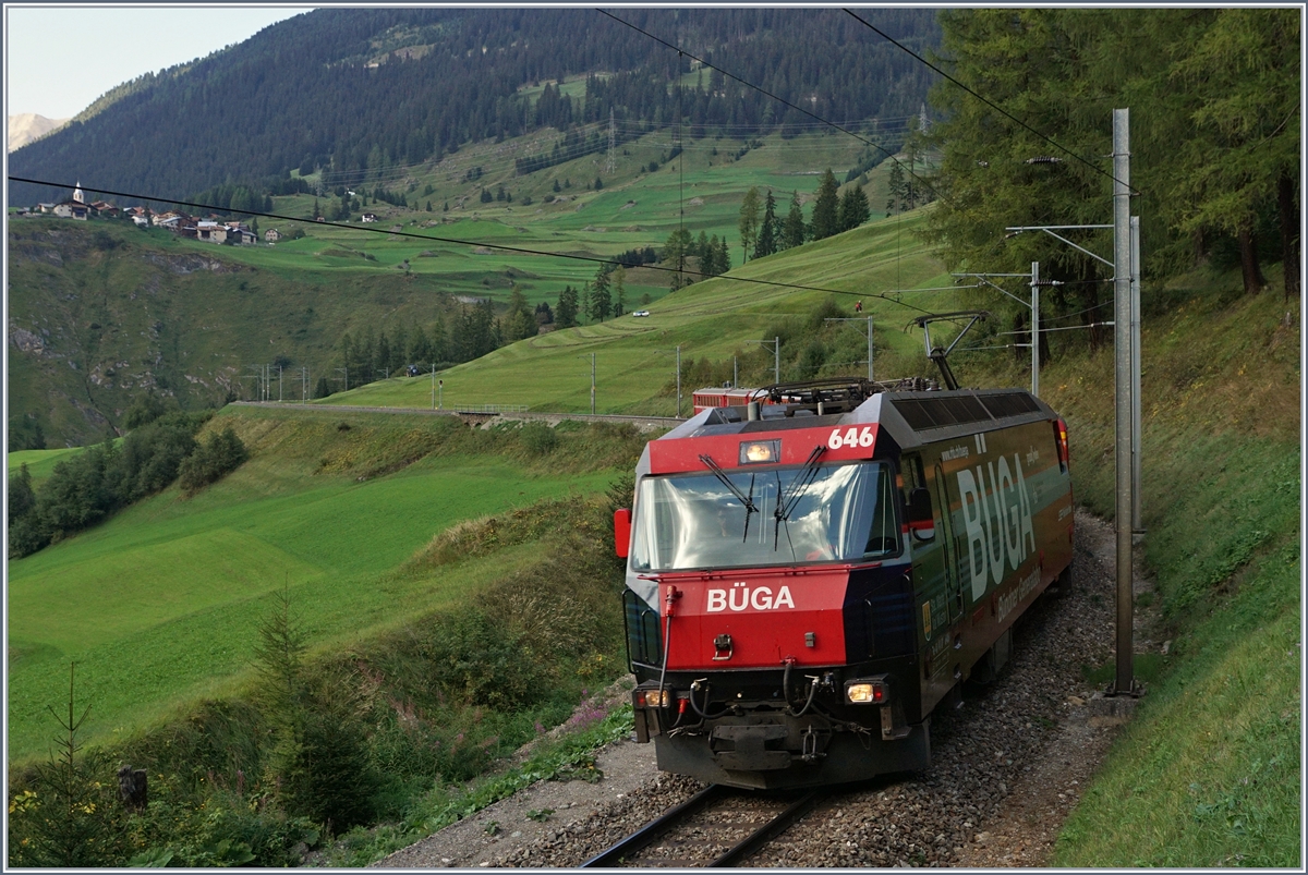Die RhB Ge 4/4 III 646  BÜGA  auf der Fahrt mit ihrem Albula-Schnellzug 1156 von St.Moritz nach Chur auf der mittleren Ebene oberhalb von Bergèn Bravuogn. Im Hintergrund, links im Bild ist der Ort Latsch zu erkennen. 
14. Sept. 2016