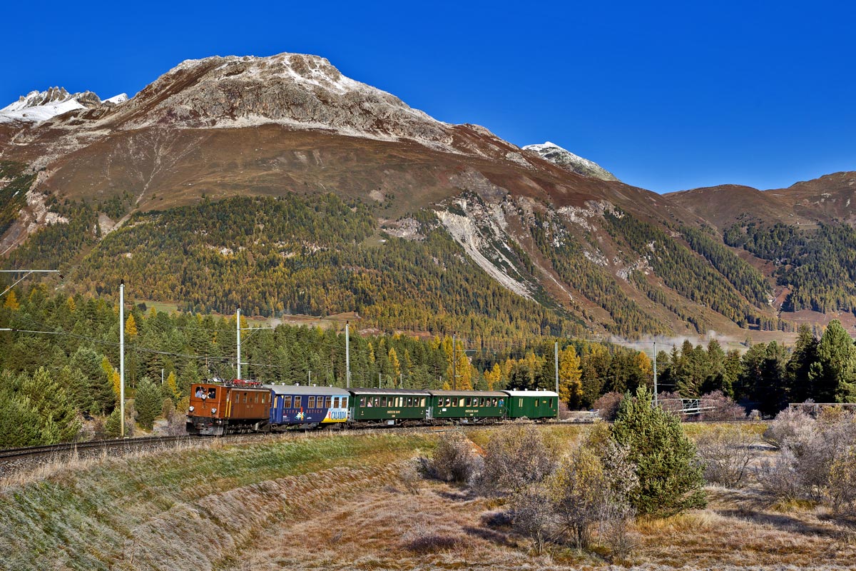Die RhB Ge 4/6 353 fährt am frühen Morgen des 16.10.2016 bei Pontresina mit dem Lunghin-Express vorbei.