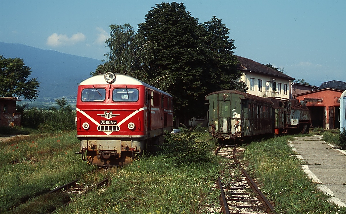 Die Rhodopenbahn mit einer Spurweite von 760 mm ist heute die einzige noch betriebene Schmalspurbahn Bulgariens. Die ca. 122 km lange Strecke führt vom 238 m hoch gelegenen Sevtemvri an der Hauptstrecke Sofia - Plovdiv über Abramovo, mit 1.267 m der höchstgelegene Bahnhof des Balkans, nach Dobroniste und braucht sich mit ihrer grandiosen Streckenführung vor keiner Alpenbahn zu verstecken. Zur Überwindung des Höhenunterschiedes war u. a. auch der Bau von Kehrtunneln erforderlich. Am 09.06.2003 rangiert die von Henschel gebaute 75 004-2 im Depot von Sevtemvri.
