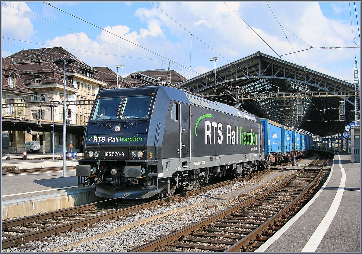 Die RTS 185 570-9 (UIC 94 80 0185 570-9) fährt mit einem Güterzug mit Last aus Brig und Visp durch den Bahnhof von Lausanne. In einer guten halben Stunde wird der Zug  erneut durch den Bahnhof von Lausanne fahren, diesmal in der Gegenrichtung, nachdem er in Lausanne Triage durch die Schleife gefahren ist und dann die Strecke Richtung Fribourg in Angriff nehmen.
28. März 2007