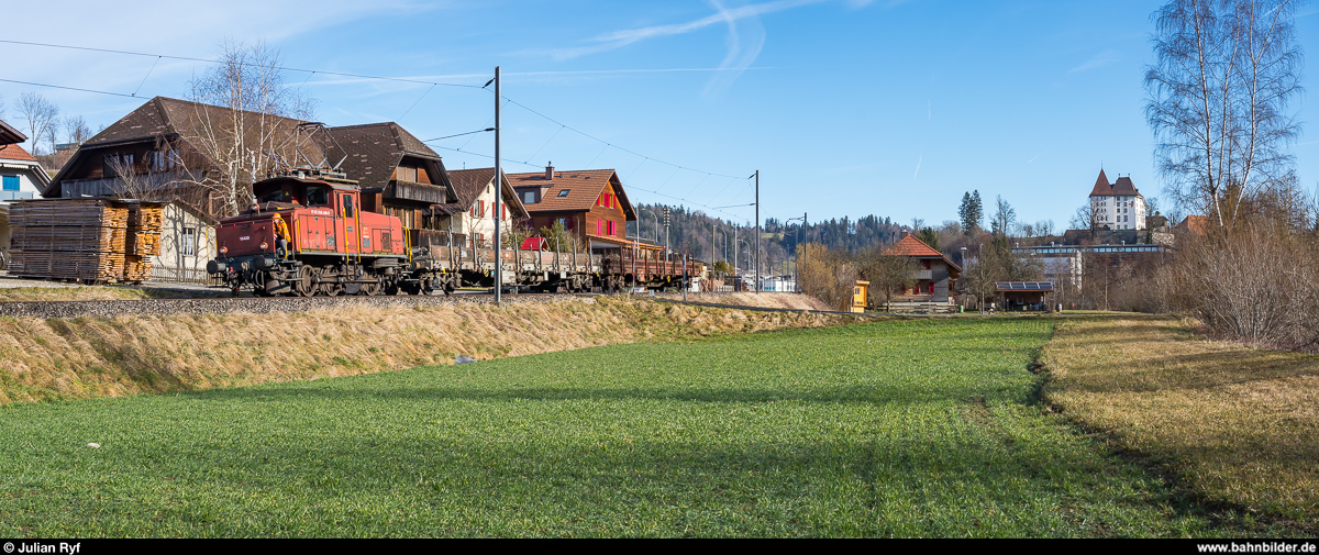Die RUWA Drahtschweisswerk AG in Sumiswald besitzt zwei Ee 3/3, welche sie für die Überfuhr der von SBB Cargo in Sumiswald-Grünen angelieferten Güterwagen zu ihrem Werk im Ortsteil Burghof an der nicht mehr für den Personenverkehr genutzten Strecke Richtung Wasen nutzt. Da die Entladerampe im firmeneigenen Anschlussgleis nur Platz für zwei Wagen bietet, werden die Wagen im Bahnhof Sumiswald-Grünen gelagert und von der Ee 3/3 jeweils paarweise ins Werk zum Entlad und danach gleich wieder zurück gebracht. Ich habe den morgendlichen Wagenwechsel am 20. Februar 2020 fotografisch dokumentiert.<br>
Nach knapp anderthalb Stunden Wartezeit waren die beiden Wagen entladen und die Ee 3/3 16408 brachte sie runter zum Bahnhof um kurz darauf zwei volle Wagen ins Werk zu bringen. Bei Ei, rechts das Schloss Sumiswald.