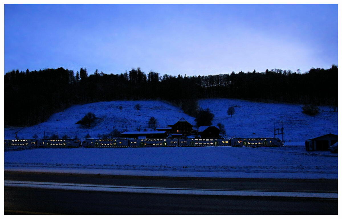 Die S-Bahn Bern, Linie S3, Biel - Bern - Belp: Beim Einnachten kommen zwei BLS MUTZ-Züge von Kehrsatz her Richtung Bern. Im Bauernhaus ist nur ein Fenster beleuchtet - ob die da zu Nacht essen? 9.Januar 2019  