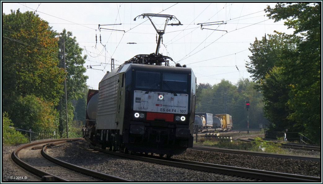 Die SBB 189 107 der MRCE mit einen gemischten Aufliegerzug am Haken im Gleisbogen bei Eschweiler ist unterwegs nach Aachen West. Szenario festgehalten am 01.Okt.2014
vom P&R Platz aus.