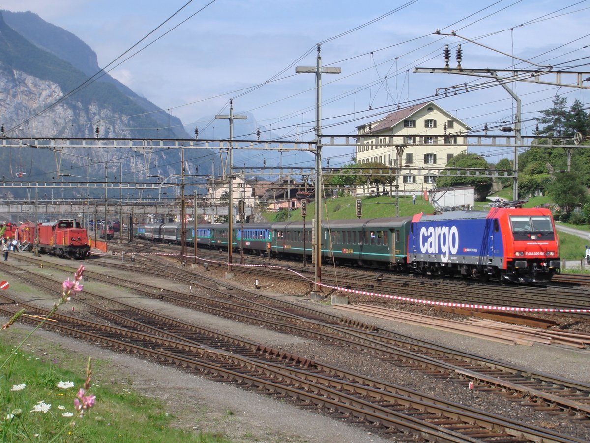 Die SBB Cargo-Re 484 020 am 8. September 2007 mit einem gemischten Gotthard-Zug bei Erstfeld. Links auf dem Festplatz zum 125 Jahr Gotthardbahn-Jubiläum die Bm 4/4 18437 mit einem Lösch- und Rettungszug.
