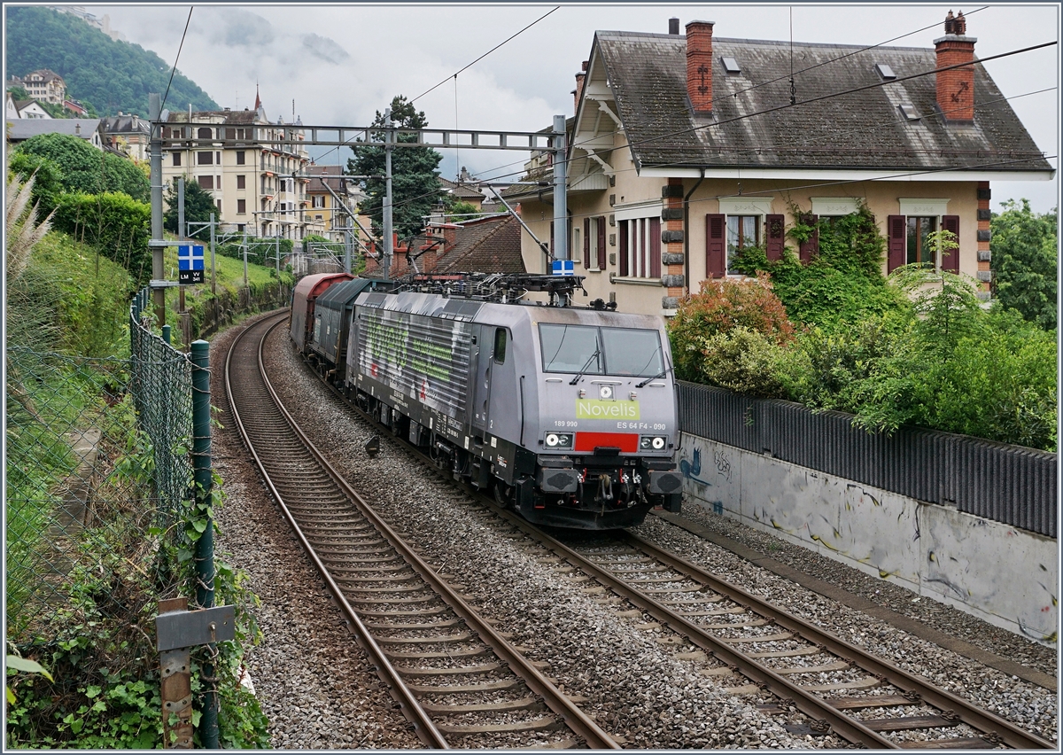 Die SBB NOVELIS  Re  189 990-5  Göttingen  (ES 64-F4-90 / UIC 91 80 6189 990-5 D-Dispo Classe 189VE) fährt mit ihrem hier nicht zu sehenden, recht langen, gemischten Novelis Zug auf dem Weg von Sierre nach Göttingen kurz nach Villeneuve in Richtung Lausanne. 

15. Mai 2020
