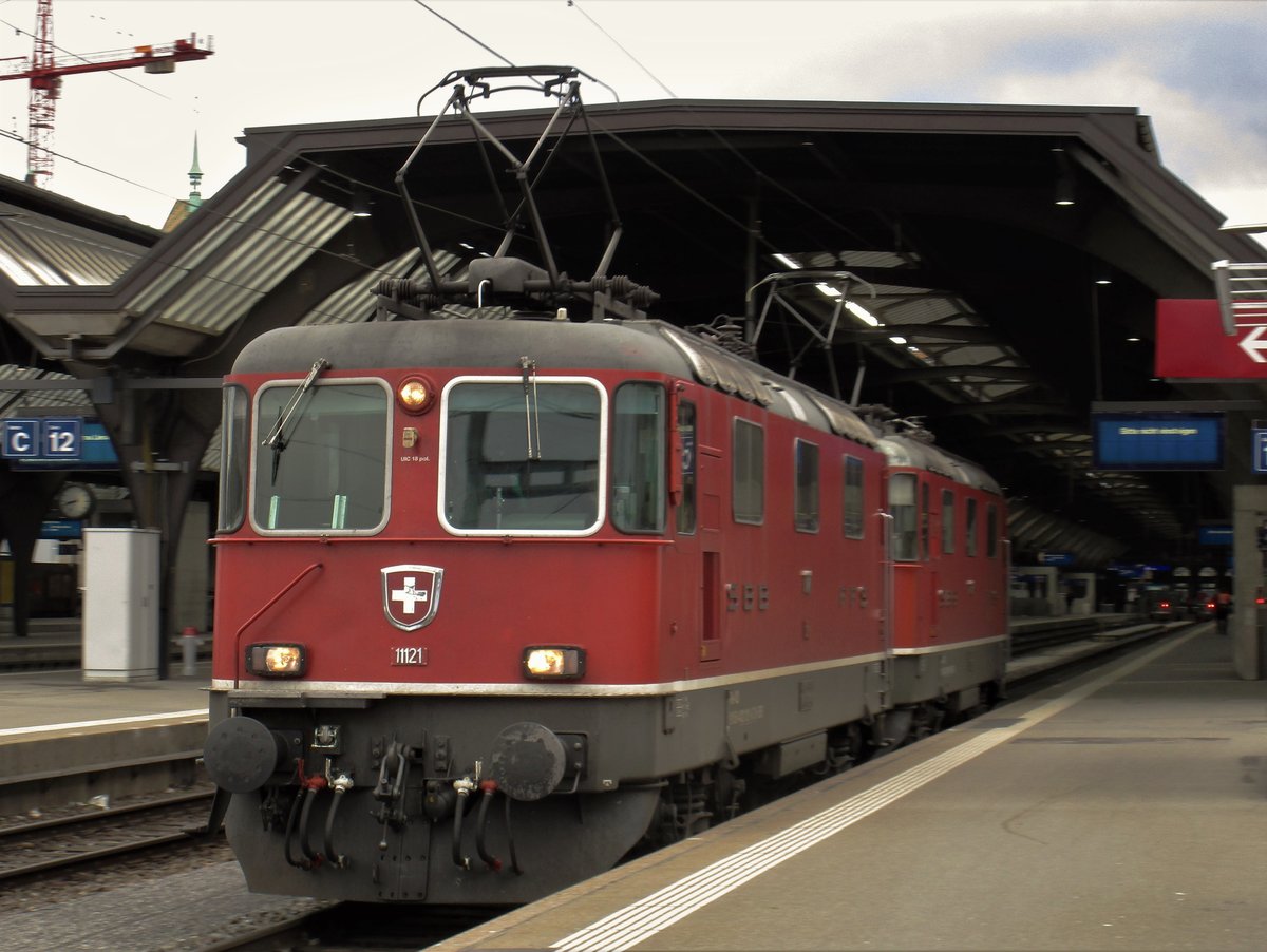 Die SBB Re 4/4 II Nr. 11129 und die SBB Re 4/4 II Nr. 11121 hatten den EN 466 Nightjet von Wien Hbf nach Zürich HB, den EN 40462 von Budapest-Keleti nach Zürich HB und den EN 50466 von Praha-Holesovice nach Zürich HB gezogen (nur einen Teil der Strecke). Im Bild fuhren die 2 leistungsstarken Loks in Doppelaktion von Gleis 11, im HB Zürich, zum einem Abstellgleis. Später mussten die 2 SBB Re 4/4 II von Gleis 18 den EN 471 Night Jet von Hamburg-Alton nach Zürich HB zum einem Abstellgleis schieben. Das Bild entstand um 8.22 Uhr.
