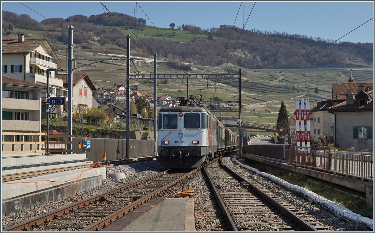 Die SBB Re 4/4 II 11256 (Re 420 256-0) erreicht mit einem Güterzug den Bahnhof von Cully. 

1. April 2021