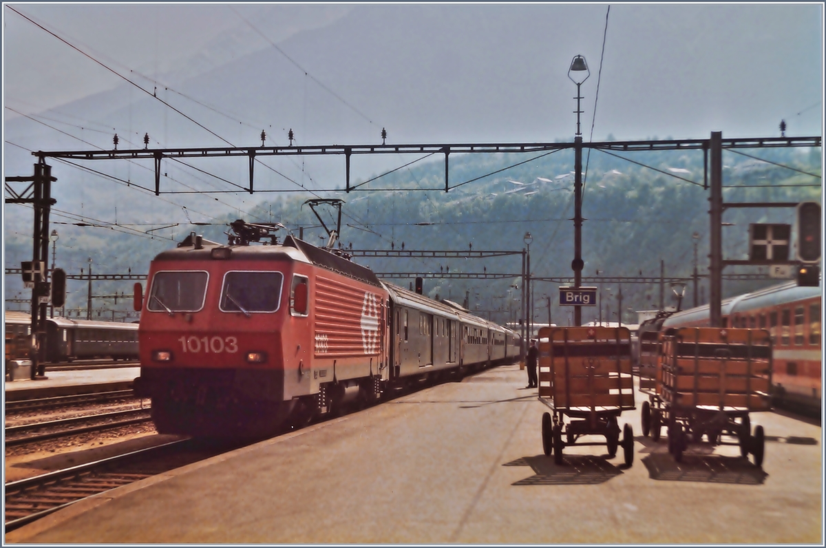 Die SBB Re 4/4 IV 10103 erreicht mit ihrem Nacht-Schnellzug Roma - Brig - Genève/Bern den Bahnhof Brig.
Analog Bild vom 24. Mai 1984