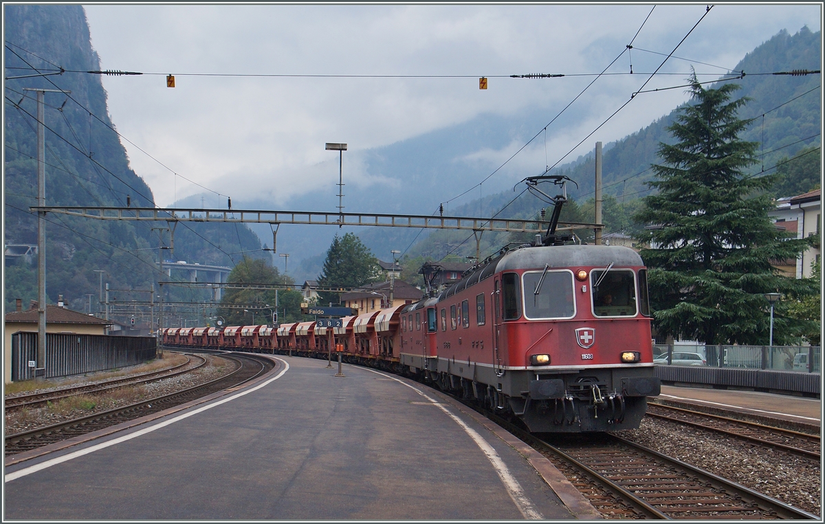 Die SBB Re 6/6 11609  Uzwil  und eine Re 4/4 II / III mit einem Kieszug auf dem Weg Richtung Bodio bei der Durchfahrt in Faido. 

22. Sept. 2015