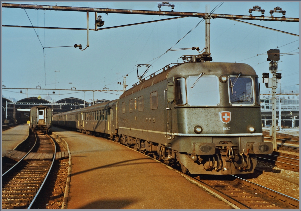 Die SBB Re 6/6 11667  Bodio  steht mit einem Gotthard Schnellzug in Luzern zur Abfahrt bereit. 

Analogbild vom 11. Dez 1984
