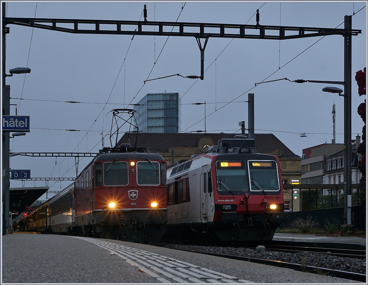 Die SBB Re4/4 11135 mit ihrem IR 1556 Neuchâtel (ab 7:22) - Lausanne (an 8:45) kurz vor der Abfahrt in Neuchâtel, daneben ein SBB RBDe 560  Domino . 

29. Okt. 2019  