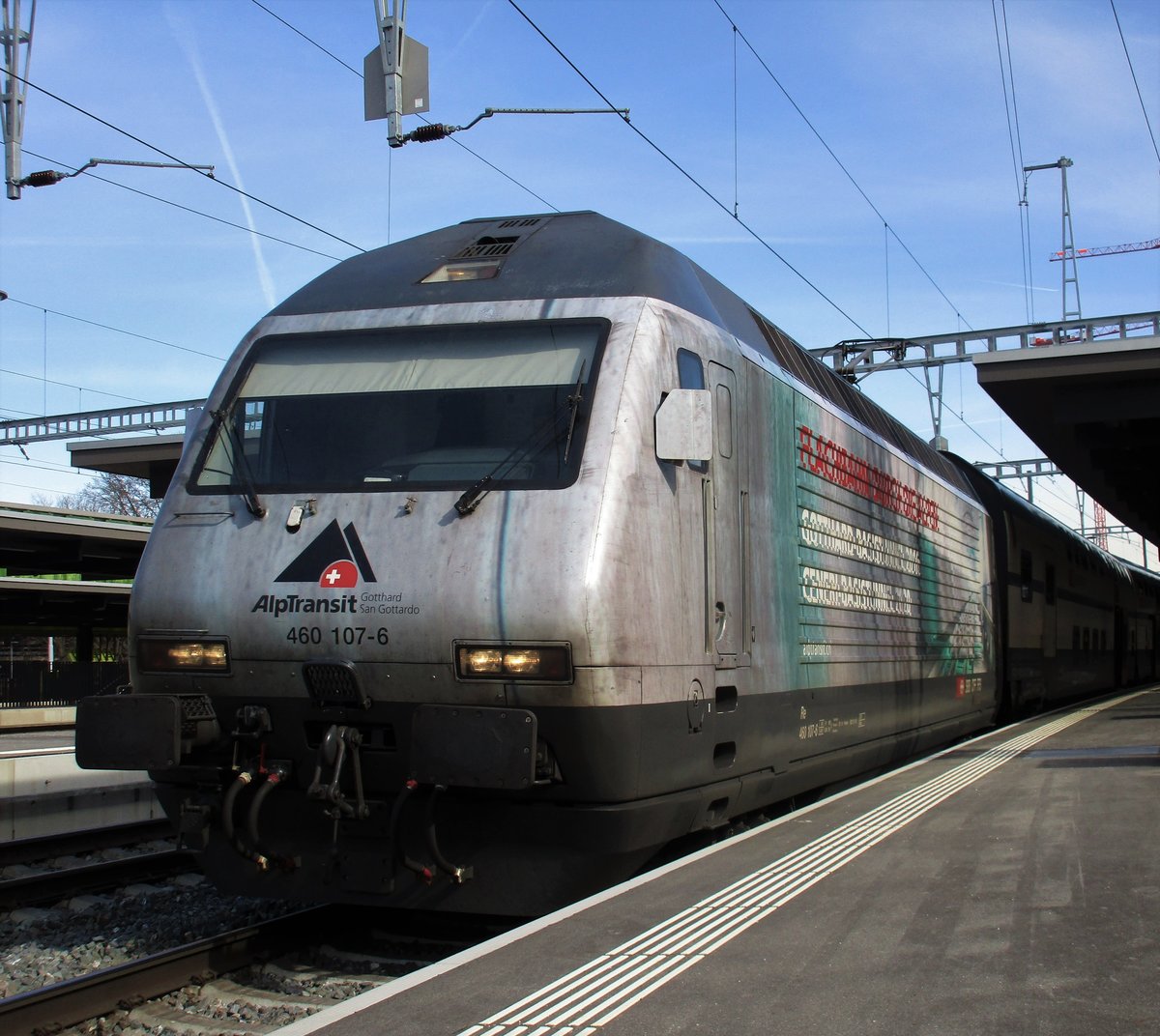 Die SBB Werbelok Re 460 107-6 mit der Werbung  AlpTransit Gotthard III  verkehrte im wunderschönen Wetter am 3.3.17 als IR 2645 nach Luzern. Die Re 460 107-6 ist die letzte erhaltene Werbelok von den 3 AlpTransit Gotthard Werbeloks. Da die SBB Werbelok Re 460 098  Gottardo 2016 schon wieder rot geworden ist wird es nicht mehr sehr lange gehen dass die anderen Gottardo 2016 (Hauptsponsoren wie Coop, Mobialiar,...,...)auch ihre Werbung verlieren und ihr Rot präsentieren. Im Bild steht der IR 2645 auf Gleis 3 im Bahnhof Zürich Oerlikon und wartet auf seine Abfahrt um 11:52 Uhr. 