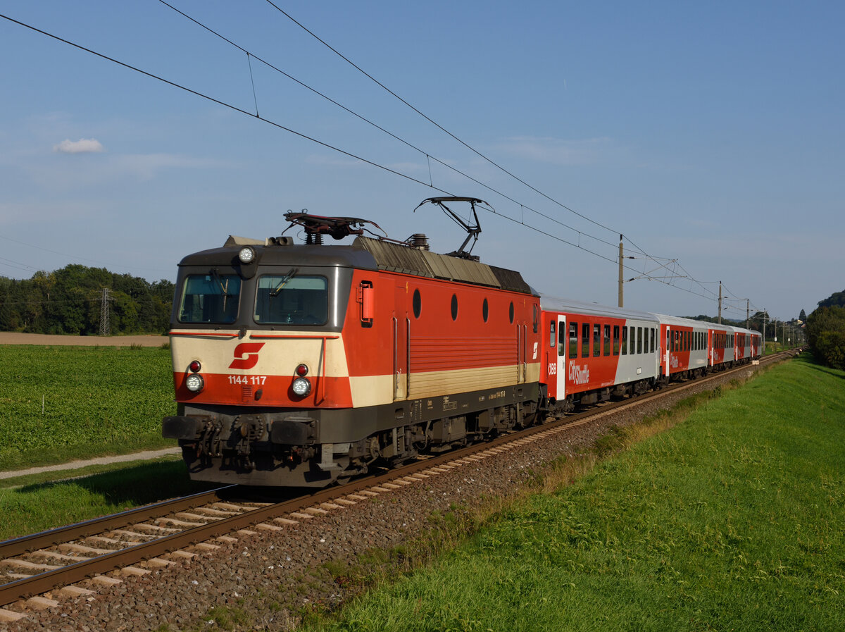 Die  Schachbrett  1144 117 bespannte am 06. September 2021 die S5, Zug 4168 von Spielfeld-Straß nach Graz Hauptbahnhof, fotografiert in Wildon.