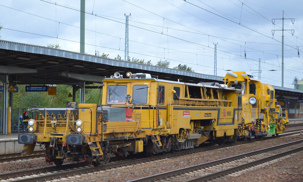Die schon etwas ältere Stopf,- Hebe- und Richtmaschine vom Typ P&T 09-32 CSM der DB Bahnbau Gruppe (GSM 338) mit der modernen Universalschotterverteil- und Planiermaschine für Gleise und Weichen mit Flankenpflügen vom TyYp P&T USP 2000-CS (SSP 338) Nr. D-DB 99 80 9125 016-2 am Haken am 18.09.19 Durchfahrt Bf. Flughafen Berlin Schönefeld.
