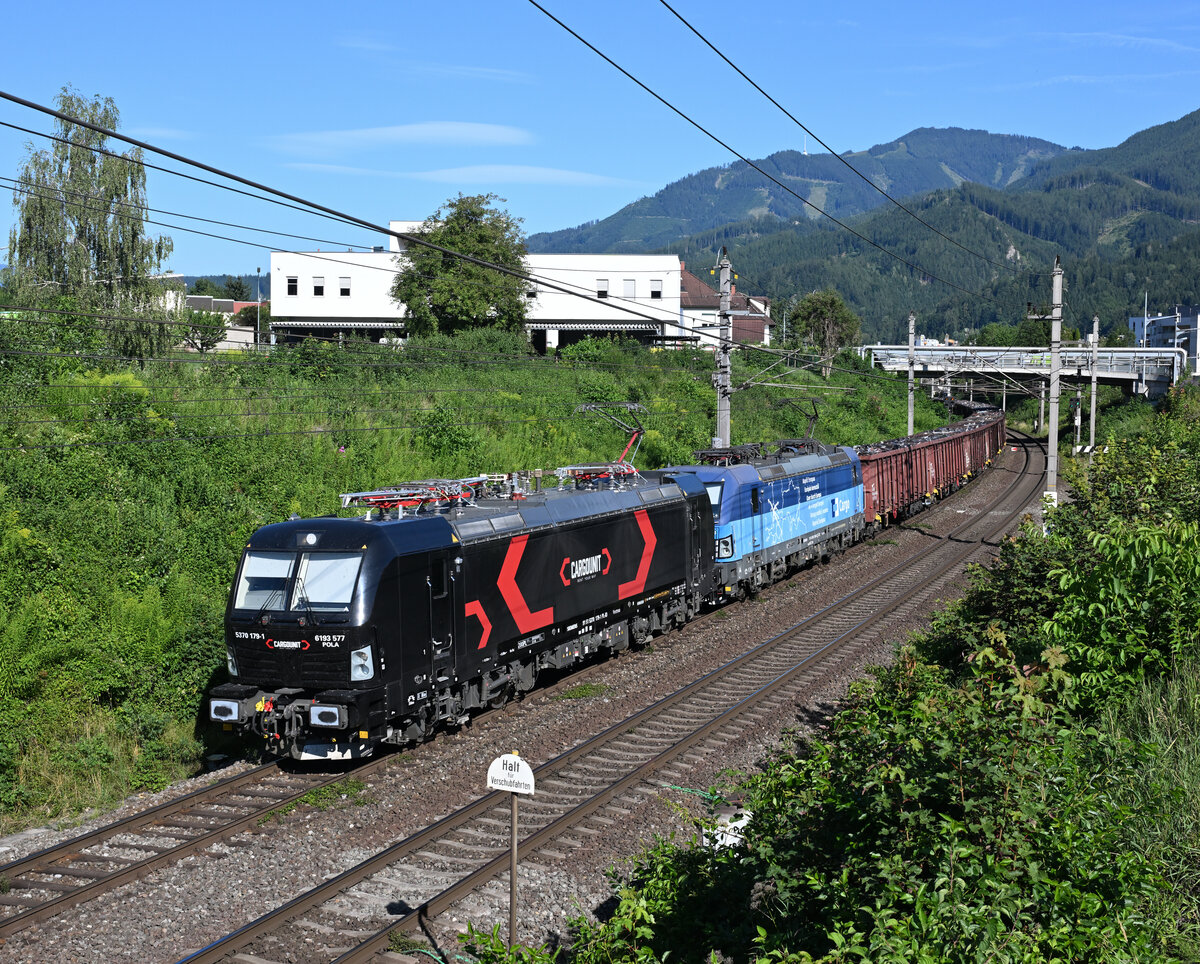 Die schwarze 370 179  Pola  angmeitet von Cargounit  sowie die blaue 383 008 von ČD Cargo traktionierten Ende Juli 2026 einen Schrottzug von Břeclav kommend via Tarvisio Boscoverde nach Italien, und wurde dabei von mir kurz vor dem Leobner Hauotbahnhof fotografiert. Im Hintergrund ist die 1630 Meter hohe Mugl zu erkennen mit der 88 Meter hohen TV- und H�rfunksendeanlage.
