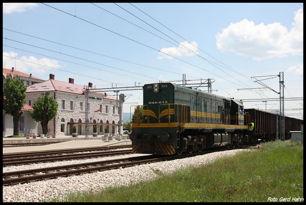 Die schwere Diesellok 644-013 der montenegrinischen Eisenbahn rangiert hier vor dem Bahnhofsgebäude in Niksic am 16.5.2017 einen Güterzug.