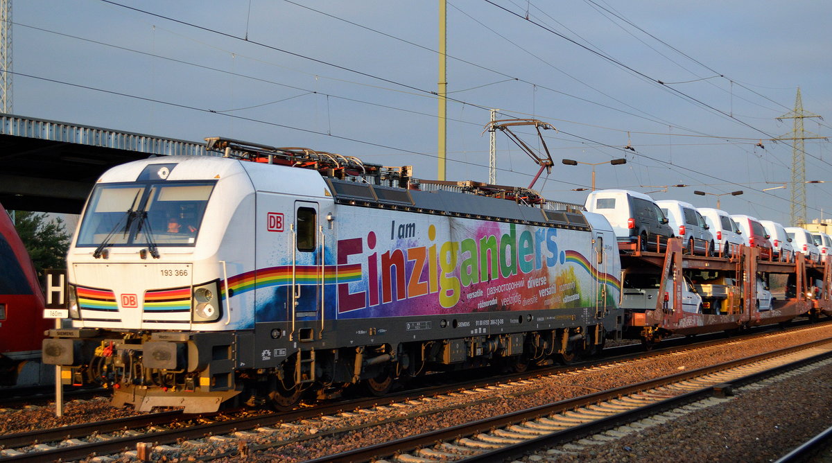 Die seit noch nicht langem sehr bunt beklebte DB Cargo Vectron  I am Einziganders.    193 366  [NVR-Nummer: 91 80 6193 366-2 D-DB] mit PKW-Transportzug (VW Nutzfahrzeuge aus polnischer Produktion) am 17.01.20 Durchfahrt Bf. Flughafen Berlin Schönefeld.