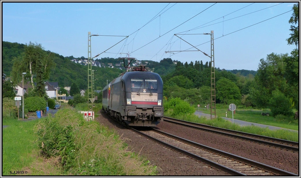 Die Siemens Lok ES 64 U2 -073 der MRCE ist mit einem EC am Haken unterwegs auf der 
rechten Rheinstrecke bei Erpel. Bildlich festgehalten im Juni 2013.