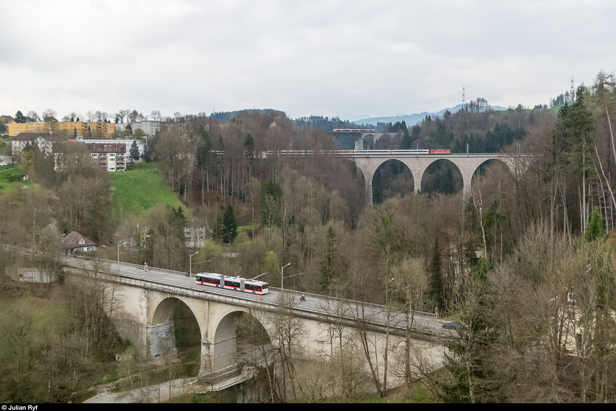 Die Sitterbrücken bei St. Gallen. Zuvorderst die Strassenbrücke mit einem Doppelgelenktrolleybus der Linie 1 in Richtung Stephansdom. Dahinter die Sitterbrücke der SBB mit einem IR nach Basel SBB, bespannt mit einer Re 4/4 II der 1. Serie. Ganz zuhinterst die höchste Eisenbahnbrücke der Schweiz, der 99 Meter hohe Sittertobelviadukt der SOB mit einem SOB-FLIRT. Aufgenommen am 5. April 2017, zusammengesetzt aus 3 Einzelbildern. Standort ist eine weitere Sitterbrücke: Die Fürstenlandbrücke der Kantonsstrasse.