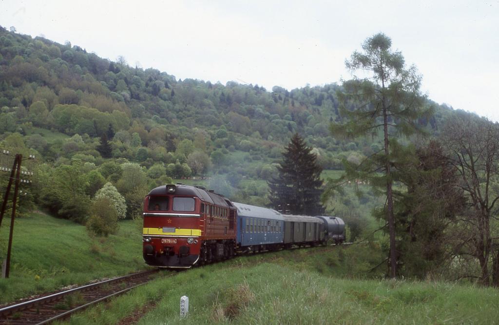 Die slowakische T 6791370, noch mit rotem Stern an der Front, folgt am 
18.5.2004 aus Richtung Zvolen kommend mit einem Feuerlschzug einem 
Dampfzug. Sie befindet sich hier kurz vor dem Bahnhof Kremnicke Bane.