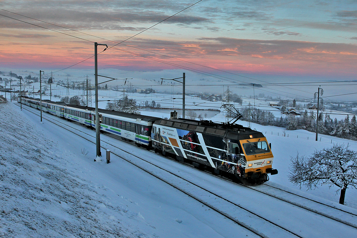 Die SOB Lokomotive 456 093,Zuglok des Voralpenexpress hat das dichte Nebelmeer über dem Zürichseegebiet hinter sich gelassen und erklimmt nun stetig die Steigung nach Schindellegi hinauf im Morgenrot des 2.1.2015
