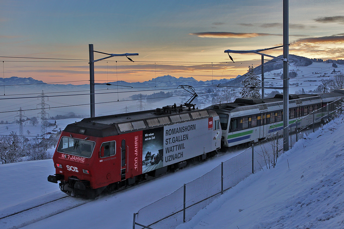 Die SOB Lokomotive 456 095 ist an diesem herrlichen Morgen im Schubdienst am VAE tätig und passiert Schindellegi,im Hintergrund rechts ist der Etzel und mittig das Säntismassiv zu erkennen.Bild 2.1.2015