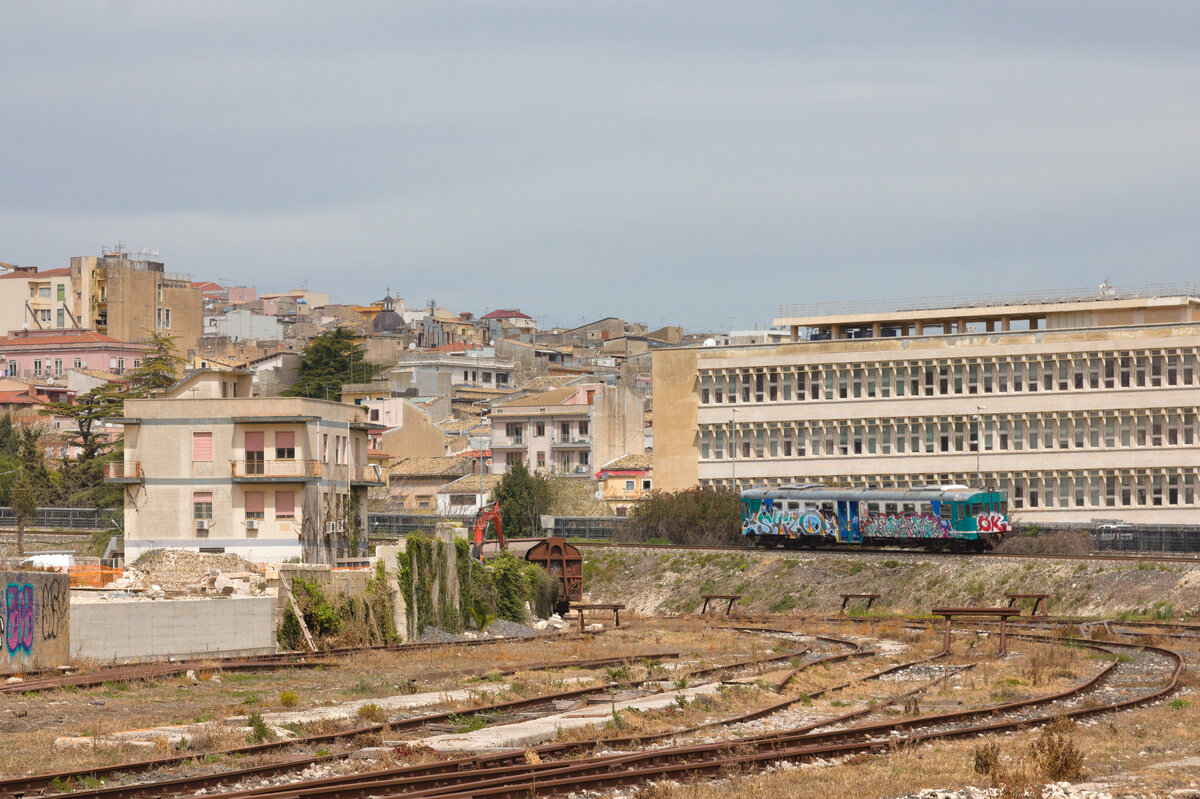 Die Stadt Ragusa im Südosten Siziliens lohnt einen Besuch. Auch wenn der Anblick des Bahnhof und dessen Umgebung anderes vermitteln möchten. Am 01.04.2023 verlässt R 12916 Siracusa-Gela den Bahnhof und erklimmt die sichtliche starke Steigung. 