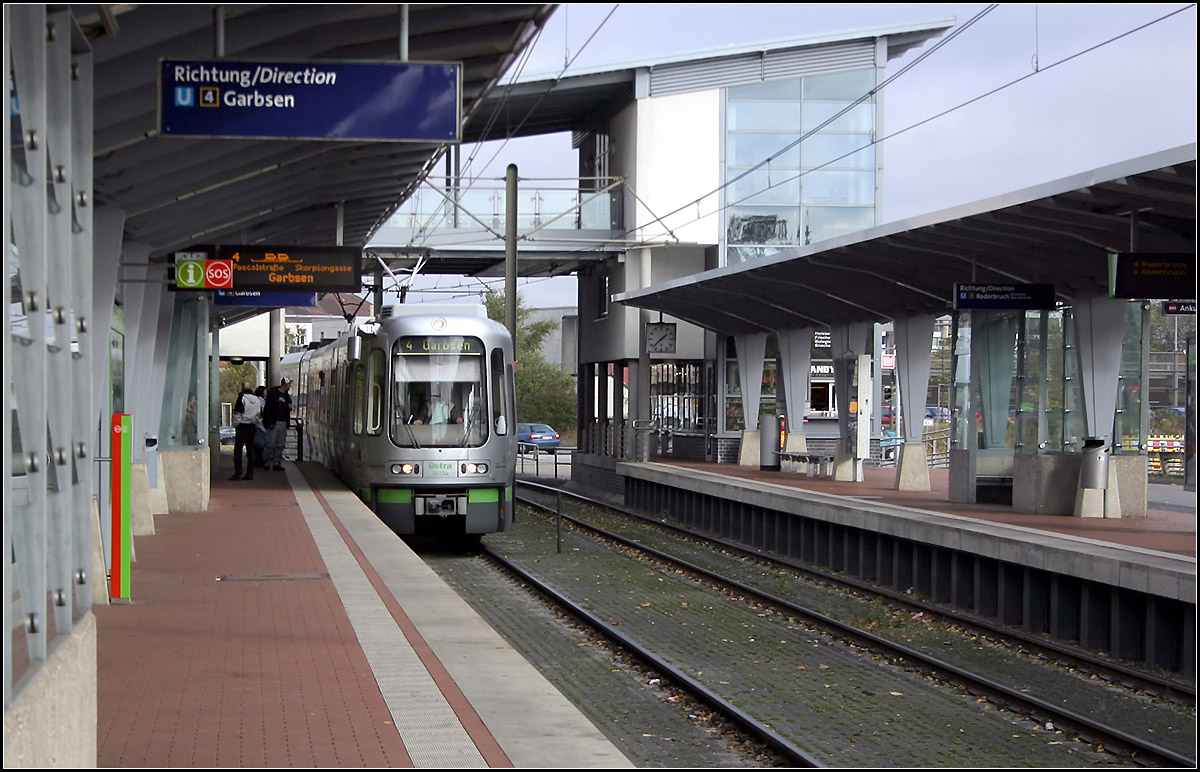 Die Stadtbahn nach Garbsen -

Blick in die aufwändig gestaltete Haltestelle Marienwerder Wissenschaftspark. Bis zur Verlängerung ins Stadtgebiet von Garbsen endete hier vorübergehend die Linie 5. Über das Brückenbauwerk sollte eigentlich ein Parkhaus angeschlossen werden, welche nicht gebaut wurde. So ist es eigentlich überflüssig, gibt es doch auch ebenerdige Überwege. Wie an zahlreichen anderen Stadtbahnhaltestellen in Hannover kann direkt gegenüber in die anschließenden Buslinien umgestiegen werden.

02.11.2006 (M)
