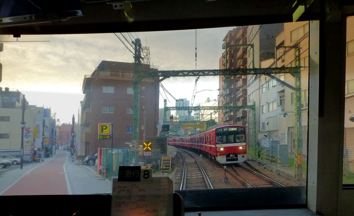 Die Stammstrecke des Keihin Kyûkô (Keikyû)-Konzerns: Ganz früh am Morgen begegnet Zug 1624 (Serie 1500) im dicht überbauten Kita Shinagawa, Tokyo, 25.Oktober 2011. 