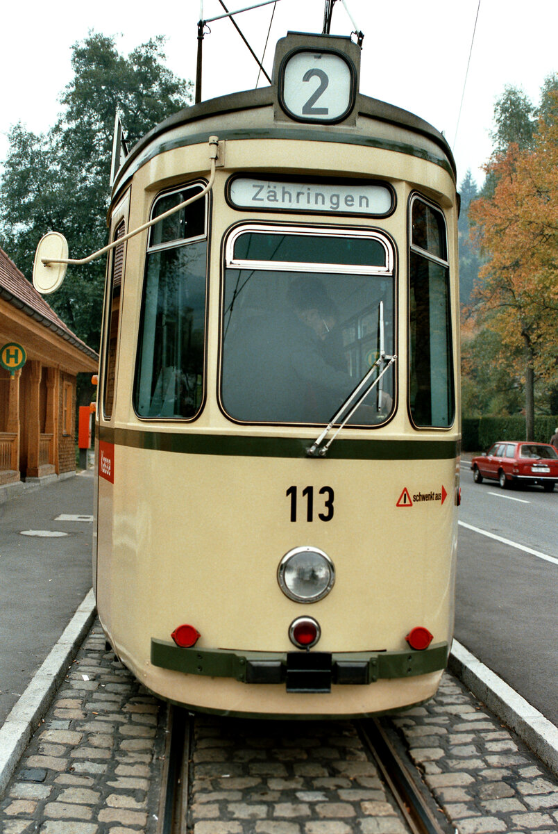 Die Station  Dorfstraße  in  Günterstal  war zu dieser Zeit schön wiederhergerichtet worden. TW 113 vom Typ GT4 wartet dort am 29.10.1983 auf seine  Weiterfahrt. Der Fahrer ist schon im Wagen.