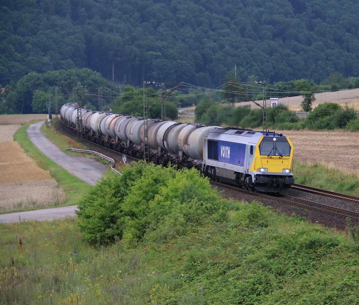 Die Stock Maxima 264 003 mit Kesselwagenzug in Fahrtrichtung Süden. Aufgenommen am 10.07.2014 bei Harrbach.