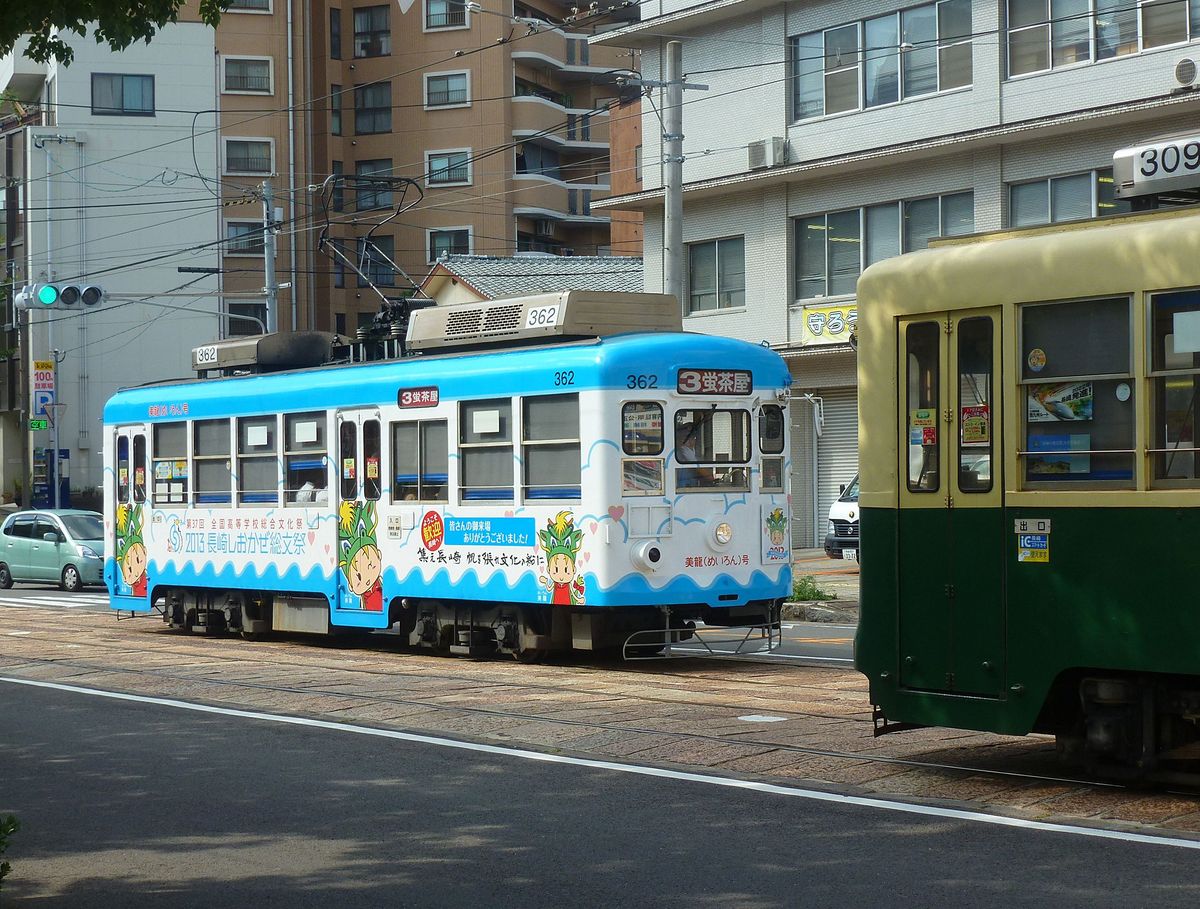 Die Strassenbahn von Nagasaki - Das Rollmaterial (Serie 361-367 und 371-377): Wagen 362 in der Innenstadt. Der Wagen wirbt für das jährliche Kulturfest repräsentativer Oberschulen aus jeder Präfektur, bei dem Wettbewerbe stattfinden in Bereichen wie Musik, Theater, Werbung, Kunsthandwerk, Malerei, Zeitungsmachen, Kalligraphie, Schach, Debattenführen, Gedichtschreiben oder Radioreportagen. 8.August 2013. 