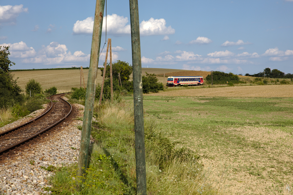 Die Strecke über der Matzendorfer Berg ist äußerst kurvig. Diese Aufnahme ist auf er Raggendorfer Seite entstanden, auf der die Telegraphenmasten noch vorhanden sind. Das Bild ist vom 1. August 2019 und zeigt den Triebwagen 5047.027.