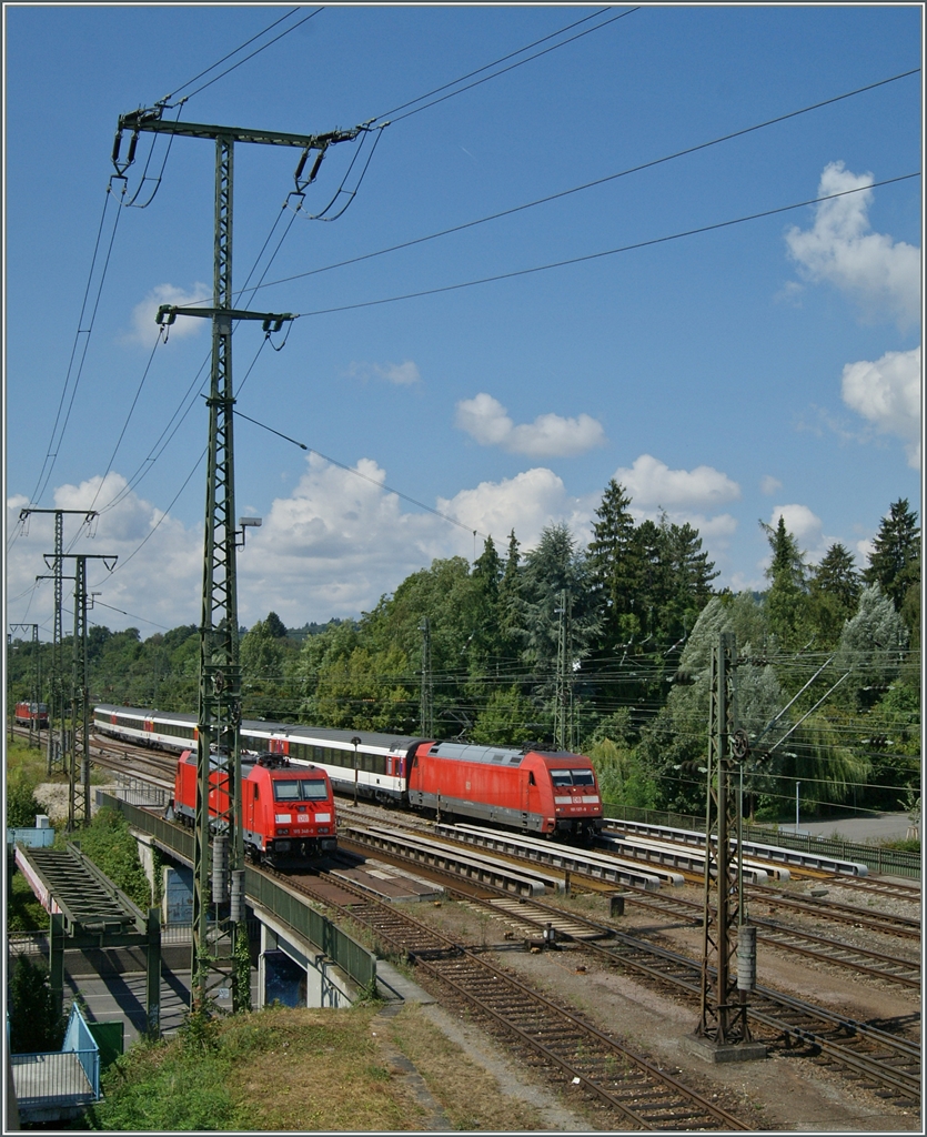 Die Strommasten waren in Singen eine echte Herausvorderung....
Während eine DB E 101 mit dem IC 183 aus Stuttgart Singen erreicht, wartet, kaum erkennbar Ablösung in Form der SBB Re 4/4 II im Hintergrund.
2. August 2015