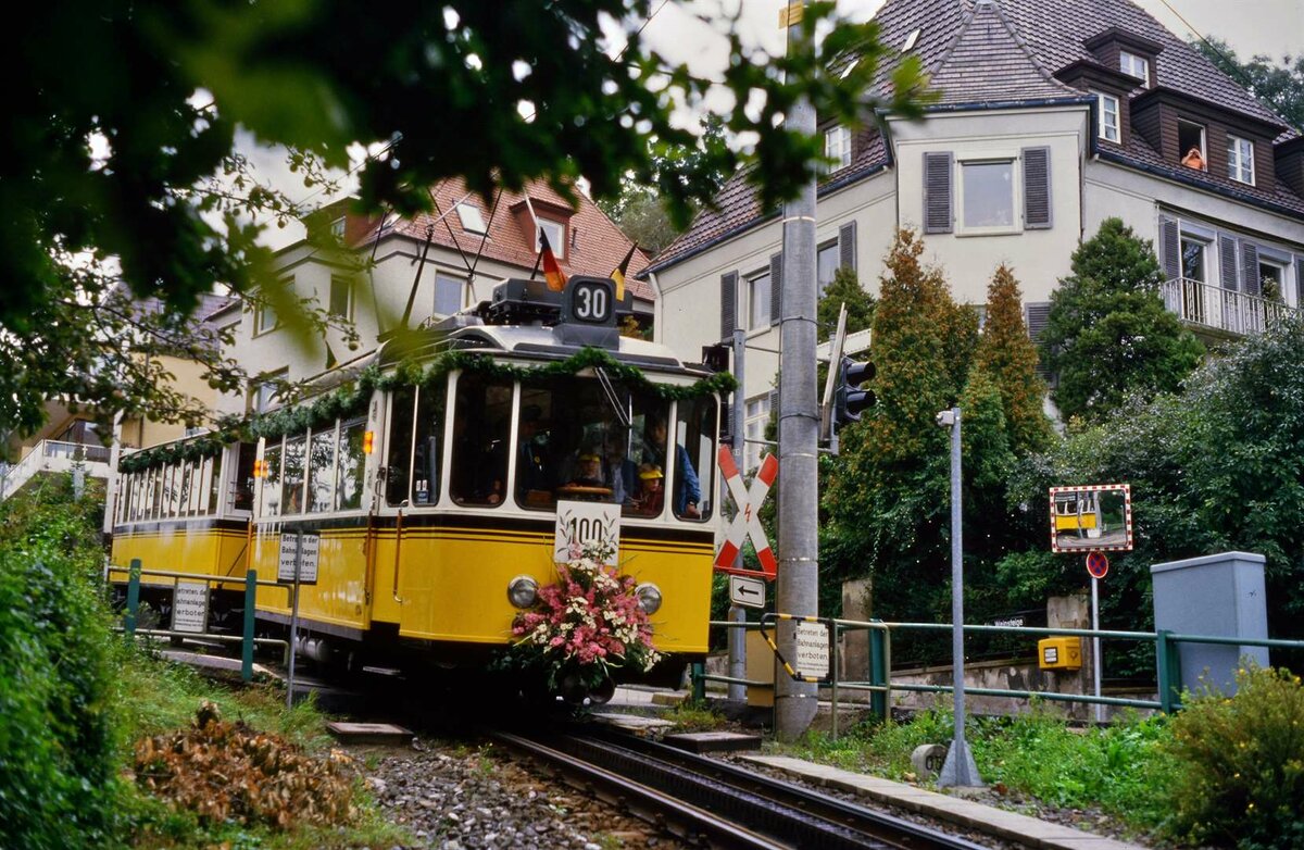 Die Stuttgarter Zahnradbahn ist 100 geworden! Ein schön geschmückter Zug mit TW 104 und Vorstellwagen 120 auf seinem Weg in Richtung Stadt.
Datum: 15.09.1984