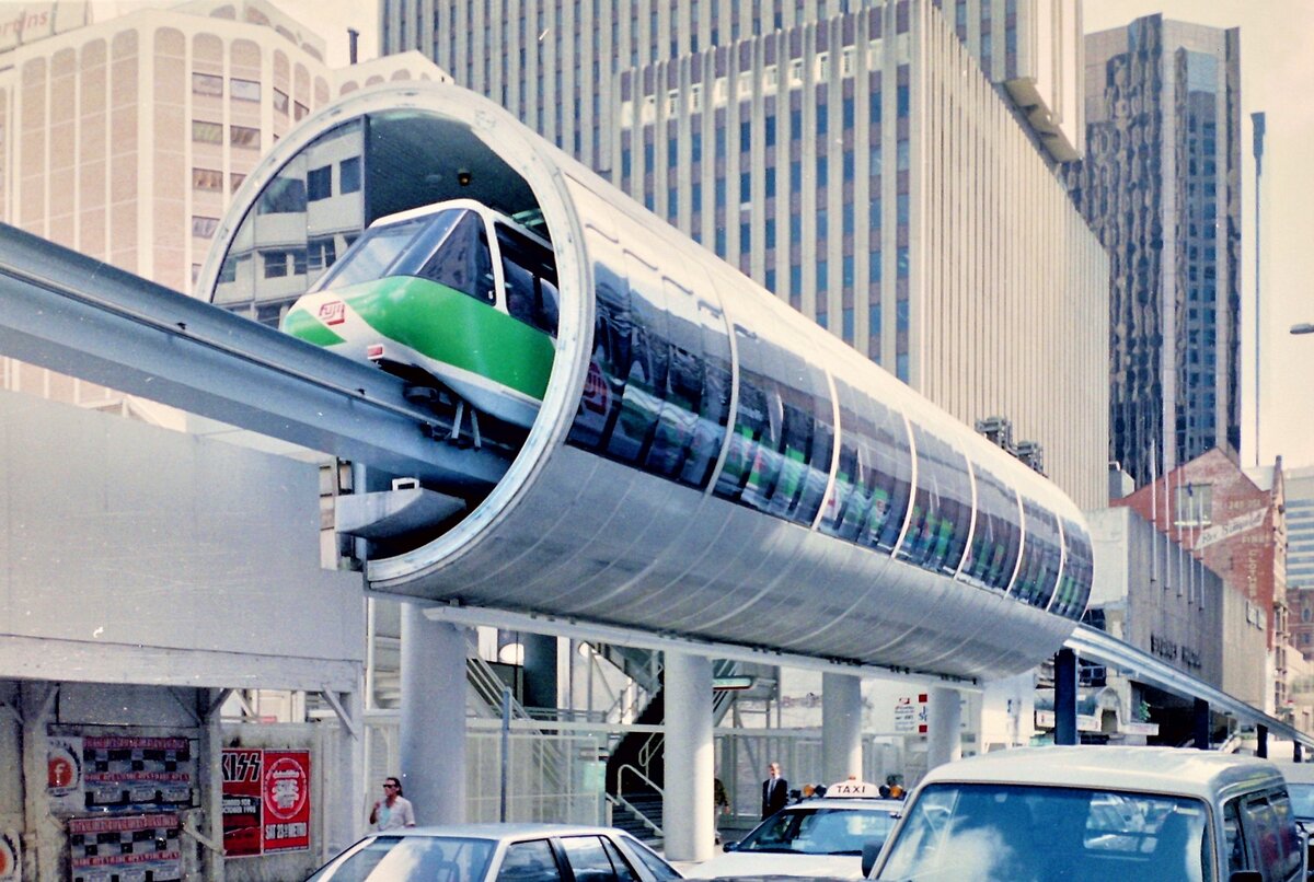 Die Sydney Monorail war eine Einschienenbahn in Sydney, die vom 21. Juli 1988 bis zum 30. Juni 2013 verkehrte. Ein Triebwagen bestand – wegen der engen Kurvenradien – aus sieben sehr kurzen gelenkig miteinander verbundenen Segmenten, war 32,12 m lang, 2,06 m breit, 2,06 m hoch und wog 35 Tonnen. Es gab fortwährende Proteste von Anwohnern, über deren Häuser die Monorail teilweise direkt verkehrte. Als weiterer Kritikpunkt wurde angeführt, dass die Monorail nicht in das restliche Nahverkehrssystem der Stadt eingebunden ist. Letztendlich trug die Monorail nichts für den ÖPNV bei, sondern wurde fast nur von Touristen benutzt. Für 2 A$ konnte man einsteigen und eigentlich bis zum Betriebsende mitfahren.
Farbnegativscan vom März 1996