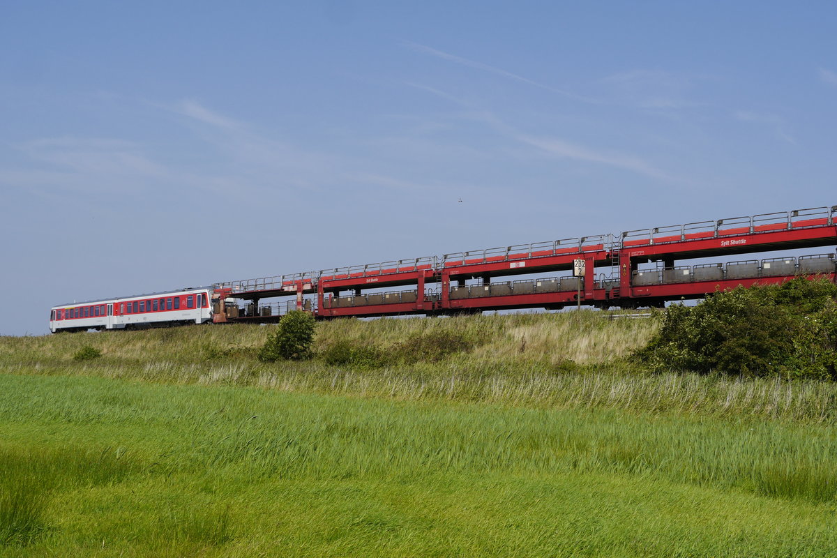 Die Sylter Lokalpresse nannte ihn den absurdesten Zug Deutschlands, den Sylt Shuttle Plus, der seit fast zwei Jahren in Form eines 628 an vielen Autozügen zwischen Niebüll und Westerland hängt. Nur vor der Konkurrenzsituation mit den RDC-Autozügen ergibt er einen Sinn. Im Bild bei Keitum (29.8.17): 628 503 auf dem Weg zum Festland, wie immer ohne Fahrgäste.
