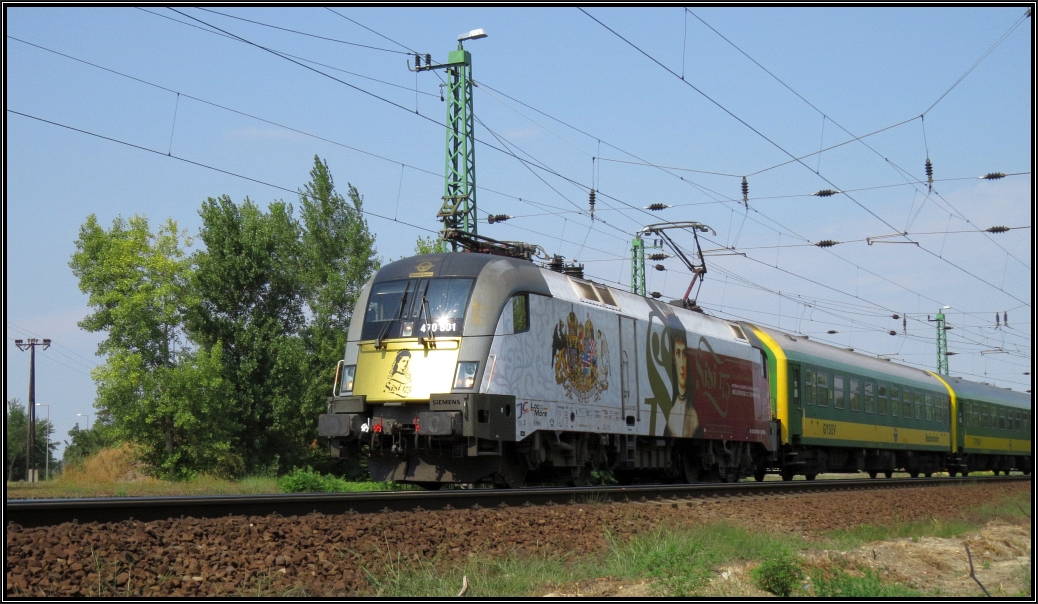 Die Taurus Lok 470 501 der Gysev im Sissi Design zieht ihren Personenzug in Richtung Györ. Hier zu sehen an der westlichen Ausfahrt von Komarom Anfang August 2015.
