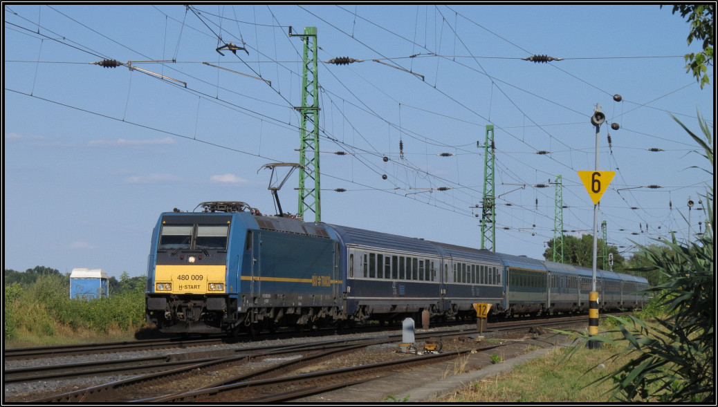Die Traxx 480 009 der MÁV-TRAKCIÓ ist mit dem Eurocity Bukarest - Wien am Haken unterwegs am Donauufer auf der Kbs 1 bei Komárom (H). Bildlich festgehalten am 31.Juli 2015.