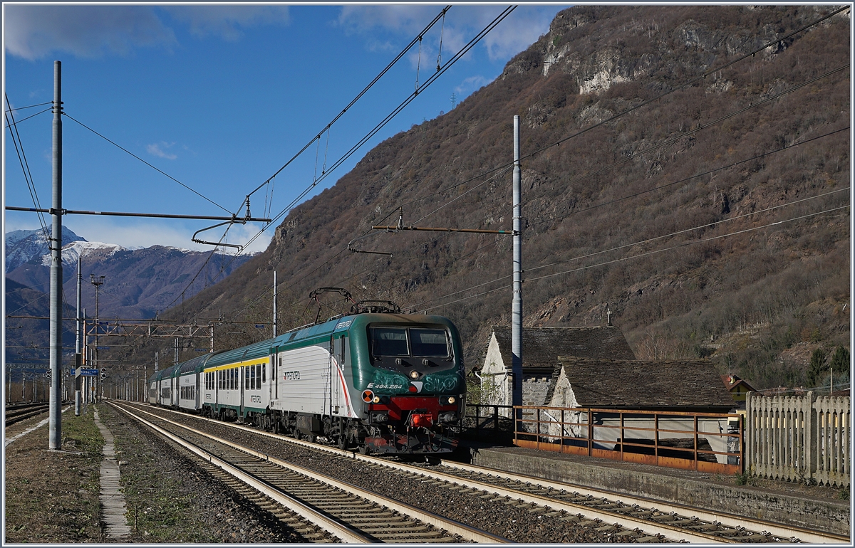 Die Trenord E 464.284 erreicht mit einem Nahverkehrszug von Domodossla nach Milano den Bahnhof Premosello-Chiovenda.

4. Dezember 2018