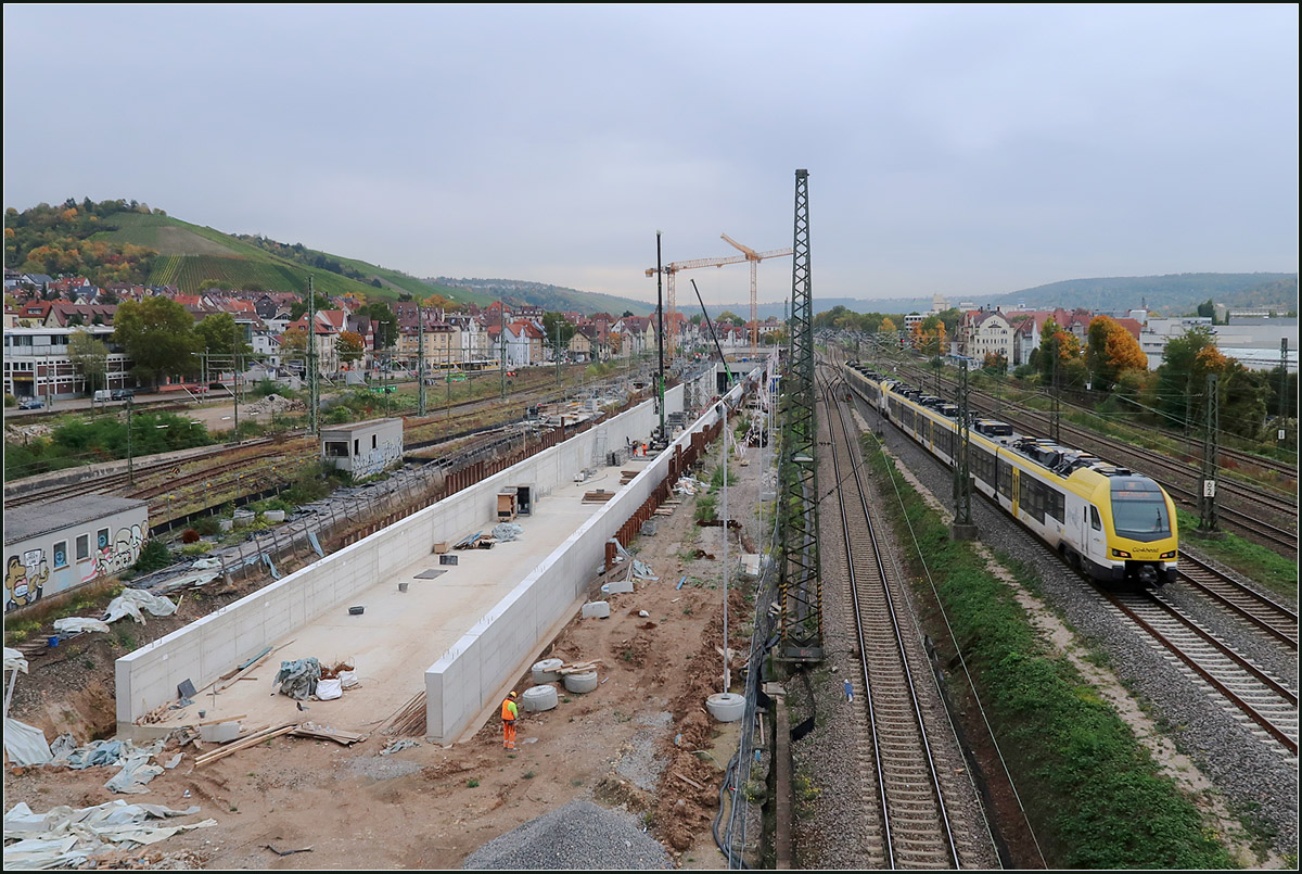 Die Tunnelrampe in Stuttgart-Untertürkheim -

Der zukünftige Abstellbahn in Stuttgart liegt in Untertürkheim. Die in Stuttgart endende Züge müssen dabei über ein 6 km langen Tunnel unter Stuttgart-Ost und unter dem Neckar hindurch dorthin gelangen. Über diesen Tunnel werden dann auch Züge aus Richtung Nürnberg und Aalen, die die in Richtung Karlsruhe durchgebunden werden den Stuttgart Hauptbahnhof erreichen und umgekehrt.
Da viele Züge der Filsbahn über die andere Tunneleinfahrt bei Obertürkheim ebenfalls diese Tunnelstrecke befahren werden, wird der Bahnhof Stuttgart-Bad Cannstatt vermutlich doch etliche Regionalzüge verlieren, da dann dieser umfahren wird. 
Theoretisch könnten Züge der Murr-, Rems- und Filsbahn, die in Stuttgart enden die neuen Tunnelstrecken als gigantische Wendeschleife befahren und jeweils vor oder nach dem Halt im Hauptbahnhof den Bahnhof in Bad Cannstatt anfahren. 

Beinahe wäre diese Fototour umsonst gewesen, war doch die Kamera auf noch auf Makro-Modus eingestellt und dies nicht bemerkt. Viele Aufnahme sind daher unscharf bis völlig verschwommen. Eigenartigerweise und zum Glück sind die Aufnahmen, auf die es mir vor allem ankam, dann doch von der Schärfe gut geworden. Normalerweise kann die Kamera im Makromodus nicht auf Motive in der Ferne scharfstellen.

21.10.2020 (M)
