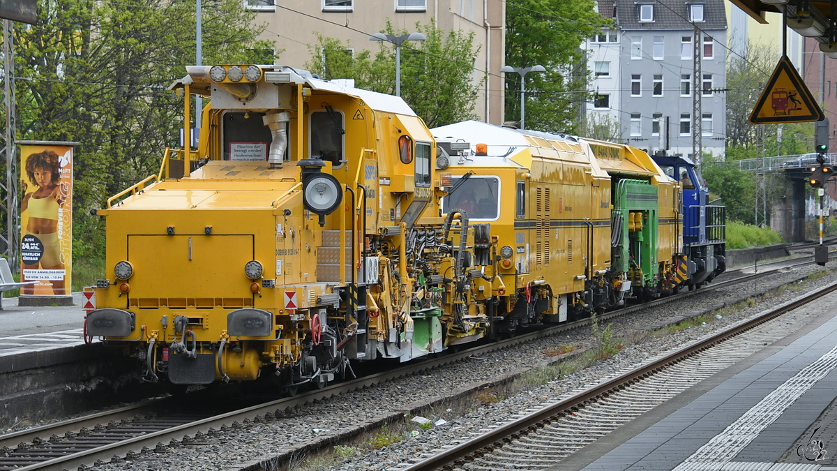 Die Universalschotterplaniermaschine USP 2000-C2  Bianka  und die Universal-Stopfmaschine UNIMAT 09-4x4/4S Y-Dynamic werden von der Diesellokomotive ESG 8 durch den Wuppertaler Stadtteil Barmen gezogen. (April 2022)