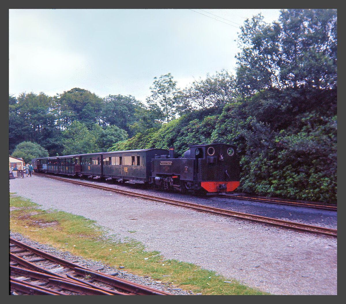 Die Vale of Rheidol Bahn in Wales. Blick zurück als die Bahn noch ein Staatsbetrieb war. Hier zeigen sich die Wagen in einem dunkelgrünen Anstrich. An der Endstation Devil's Bridge (wo es tatsächlich eine ganz ungeheure Brücke über eine wilde Schlucht gibt) wartet Lok 9  Prince of Wales  auf die Rückfahrt nach Aberystwyth. 20.Juli 1964  