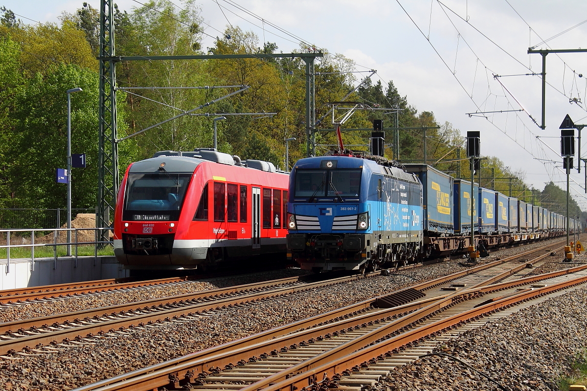 Die Vectron der CD 383 007-2 überholt mit einem KLV-Zug den LINT 41 (648 611-1) am 25.04.2018 auf dem Bahnhof Nassenheide.
