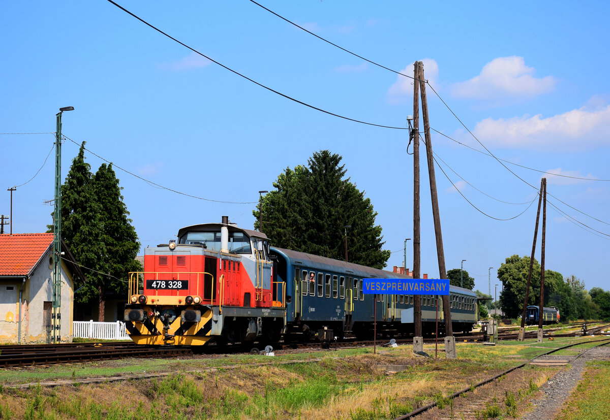 Die Verschublok 478 328 mit dem Personenzug von Győr nach Veszprém auf der Bakonybahn bei der Abfahrt von Bf. Veszprémvarsány.
24.07.2021.
